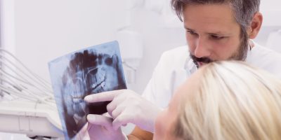 Dentist showing x-ray to the patient in clinic