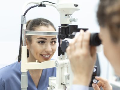 Eye doctor with female patient during an examination in modern clinic. Ophthalmologist is using special medical equipment for eye health Eye doctor with female patient during an examination in modern clinic. Ophthalmologist is using special medical equipment for eye health